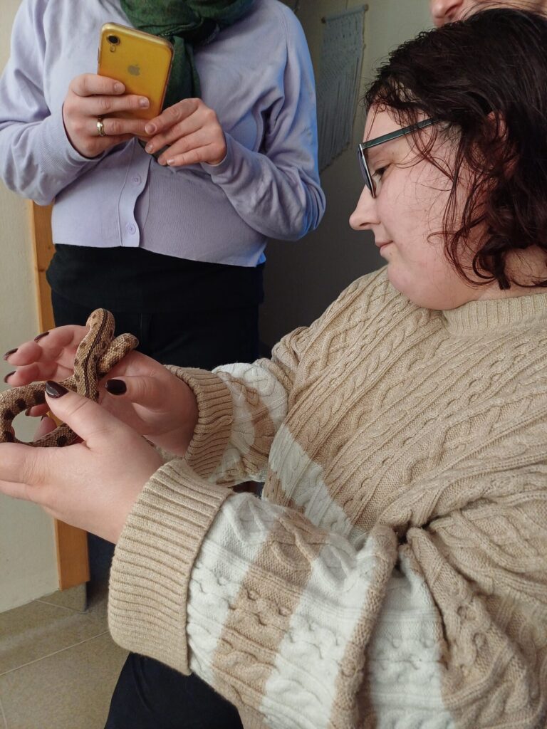 Podopieczna ŚDS trzyma w rękach węża