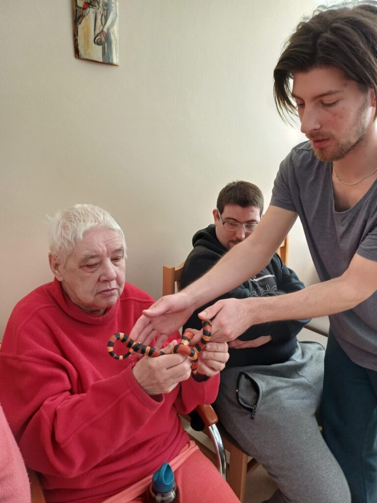 Podopieczna ŚDS trzyma w rękach węża