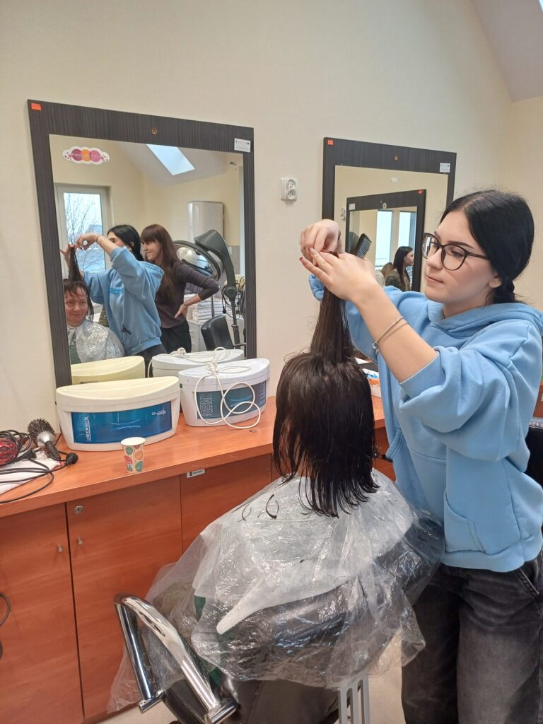Podopieczna ŚDS ma strzyżone włosy przez uczennicę klasy fryzjerskiej Zespołu Szkół w Gdowie