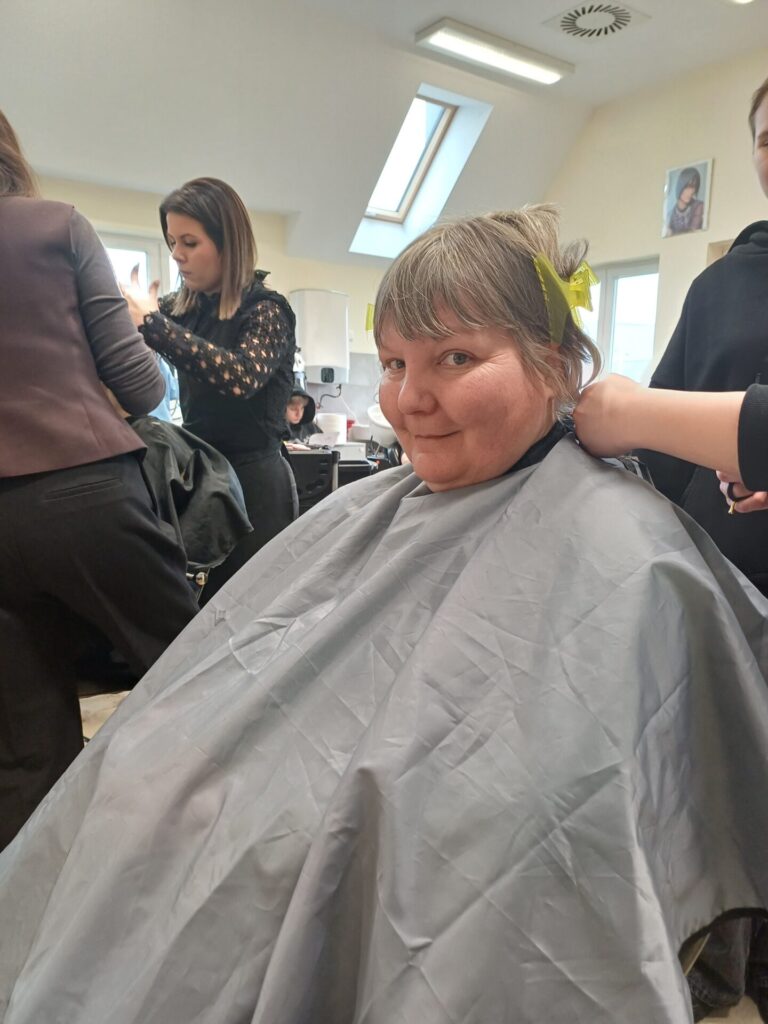 Podopieczna ŚDS ma strzyżone włosy przez uczennicę klasy fryzjerskiej Zespołu Szkół w Gdowie