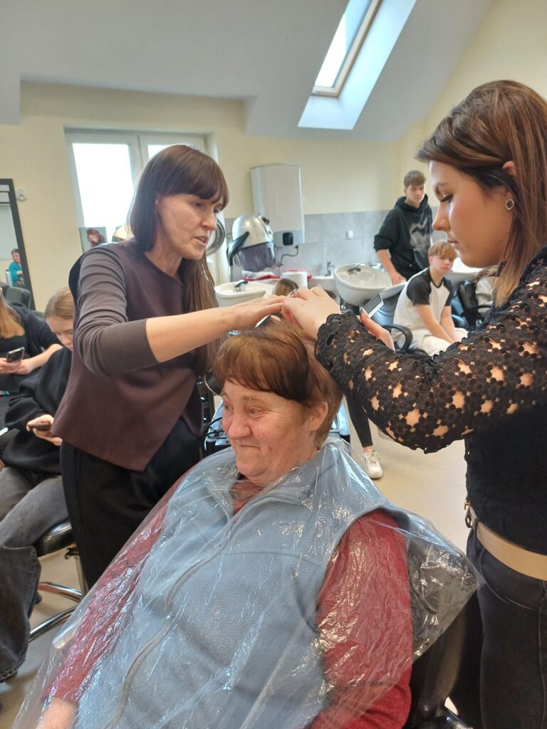 Podopieczna ŚDS ma strzyżone włosy przez uczennicę klasy fryzjerskiej Zespołu Szkół w Gdowie