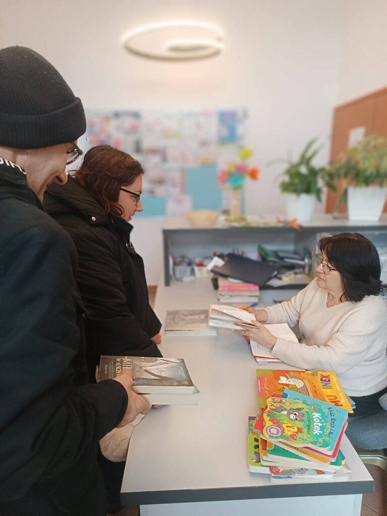 Podopieczni wypożyczają książki w bibliotece
