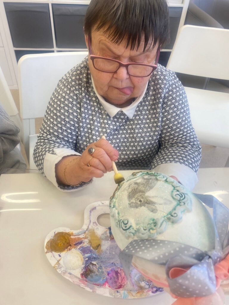 Podopieczna wykonuje jajko w technice decoupage