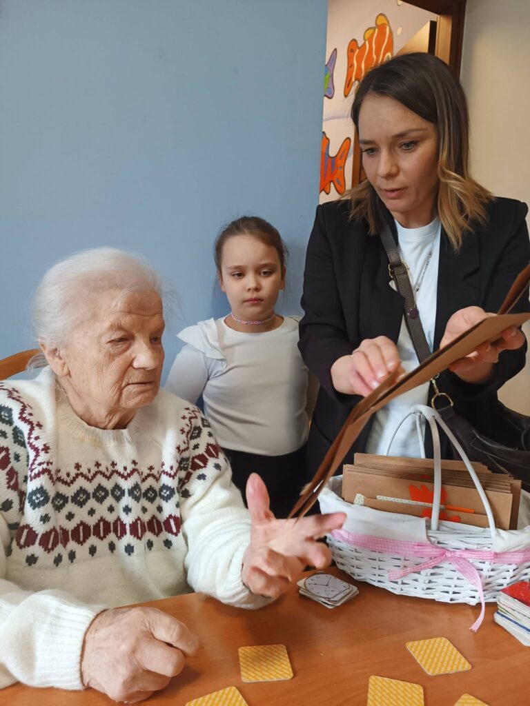 Pani nauczycielka wręcza podopiecznej kartkę świąteczną
