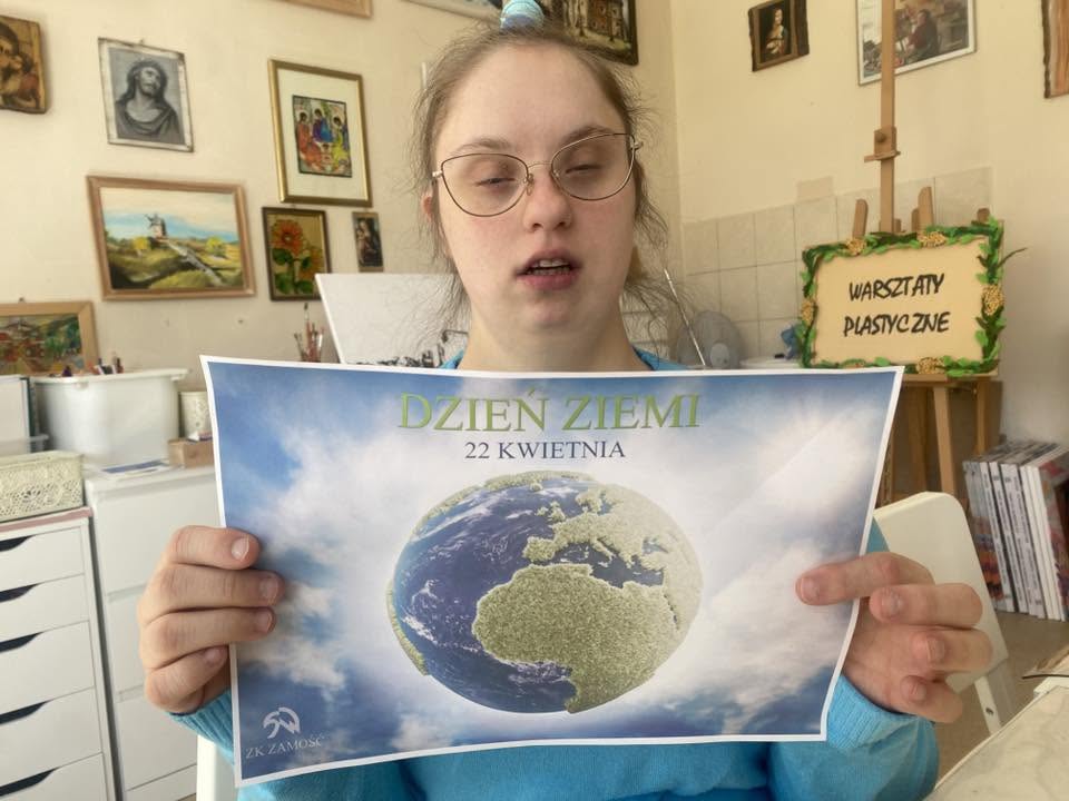Podopieczna pozuje z plakatem dotyczącym Dnia Ziemi