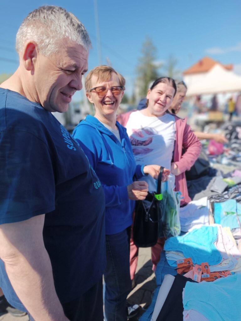 Podopieczni wybierają bieliznę podczas zakupów na jarmarku