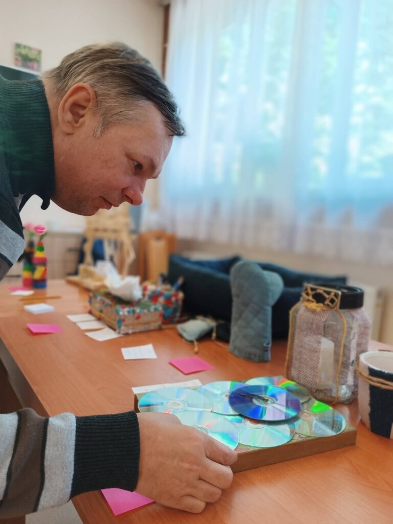 Podopieczny ocenia prace zgłoszone do konkursu recyklingowego