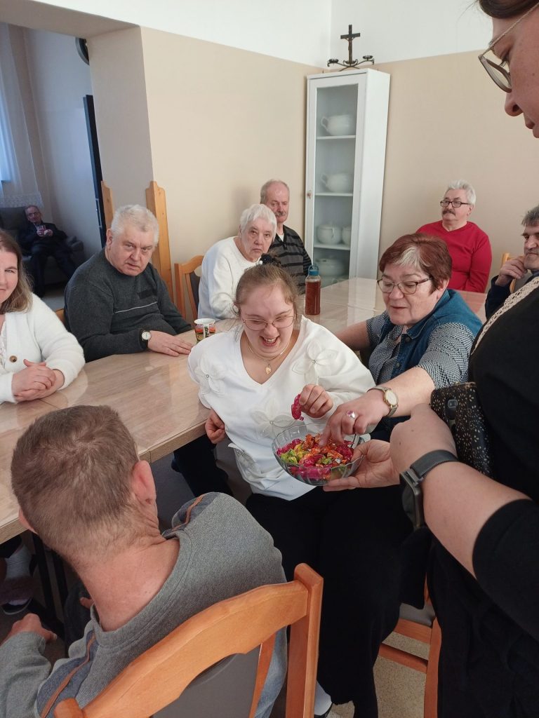 grupa osób częstuje się cukierkami