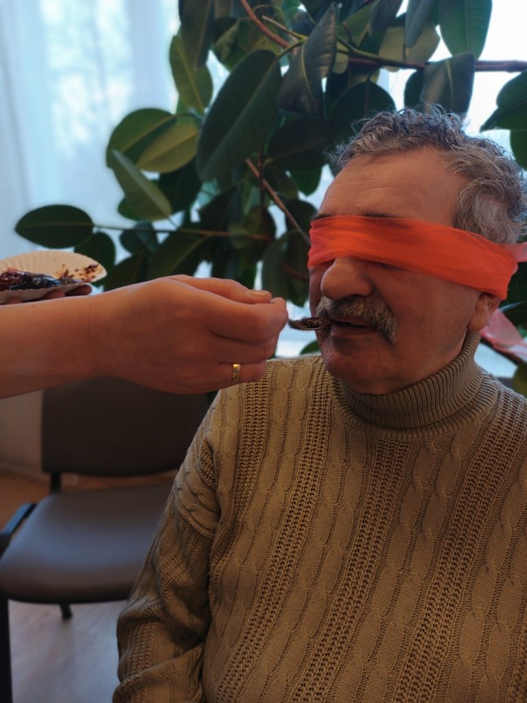 Podopieczny  z zamkniętymi oczami testuje smak dżemu