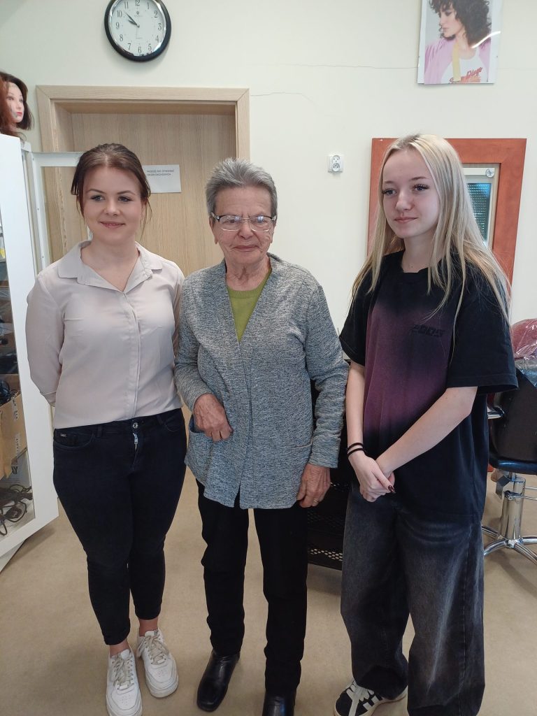 Uczennice klasy fryzjerskiej prezentują swoją pracę wraz z modelką (Podopieczną)