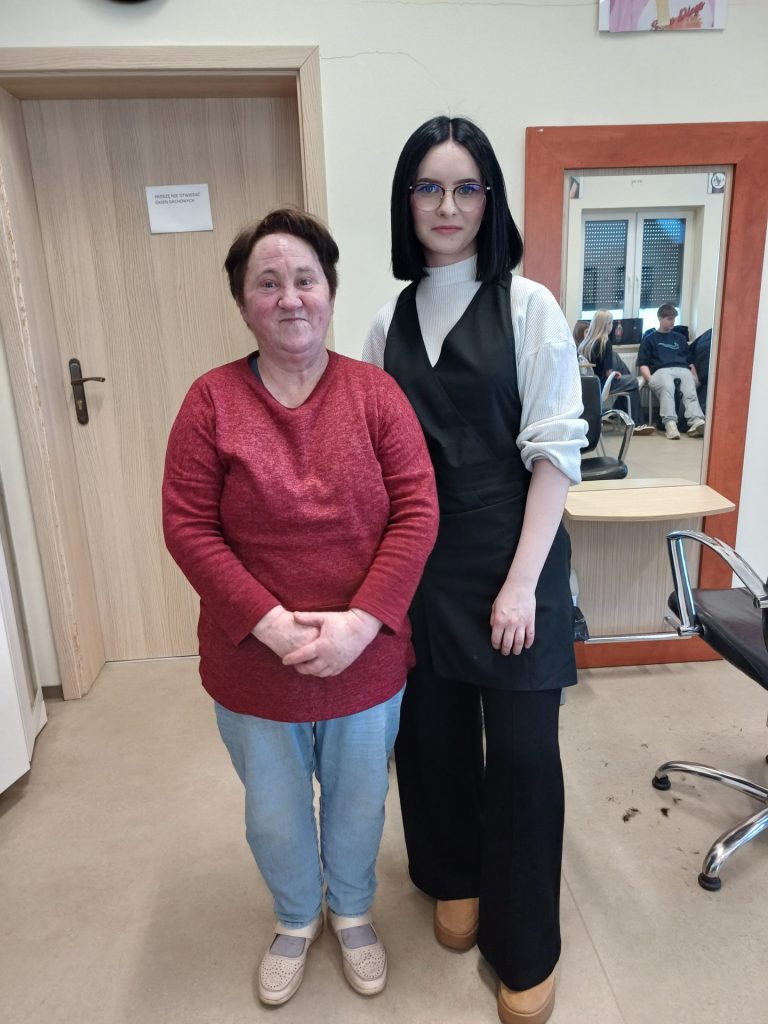 Uczennica klasy fryzjerskiej prezentuje swoją pracę wraz z modelką (Podopieczną)