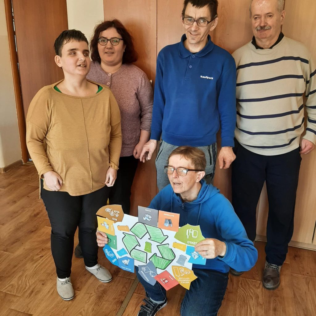 Podopieczni prezentują plakat dotyczący recyklingu