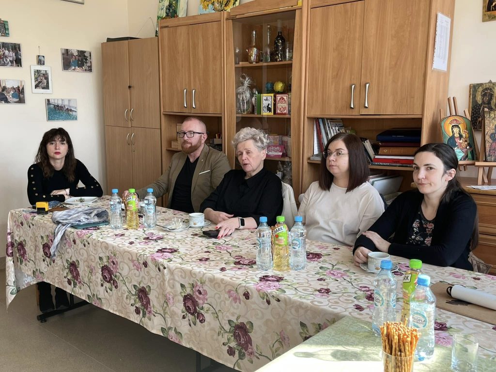 grupa osób uczestniczy w spotkaniu