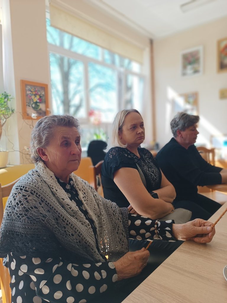 Uczestnicy spotkania Grupy wsparcia rozmawiają przy wspólnym stole