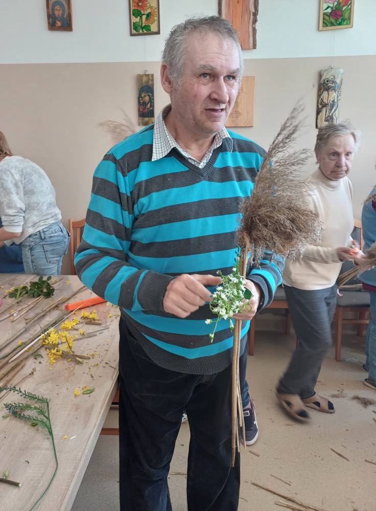 Podopieczny prezentuje wykonaną przez siebie palmę wielkanocną