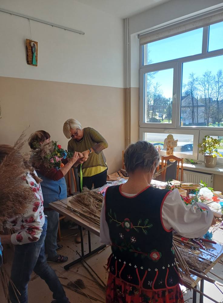 Uczestnicy wraz z paniami z KGW wykonują palmy wielkanocne