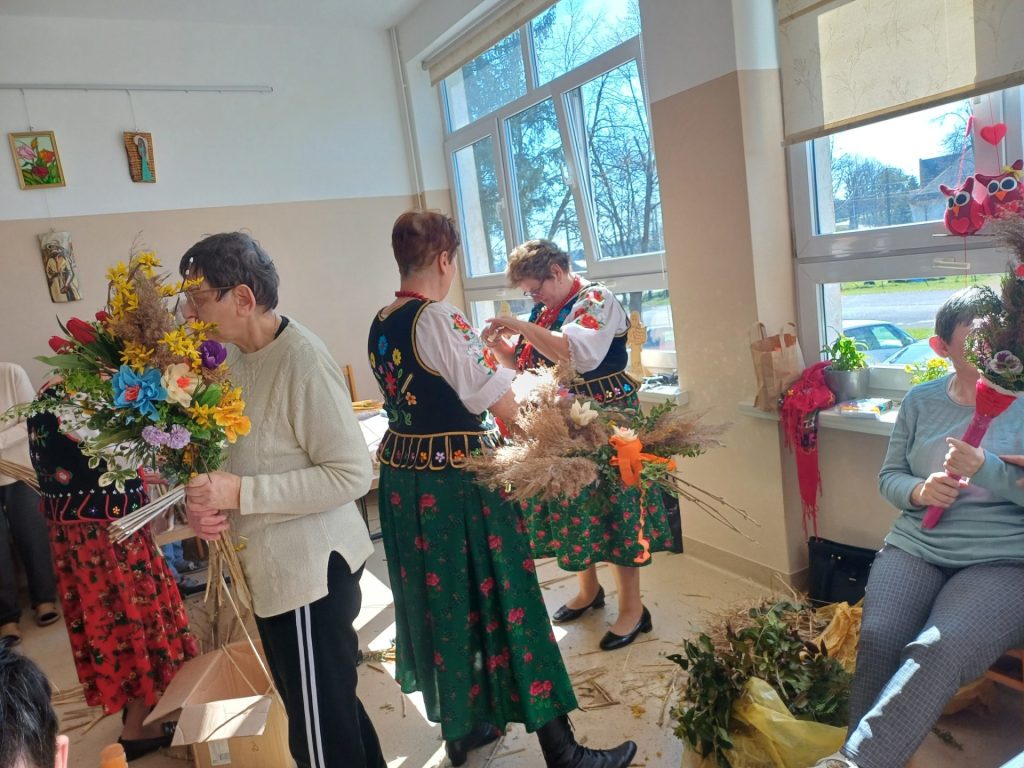 Uczestnicy wraz z paniami z KGW wykonują palmy wielkanocne