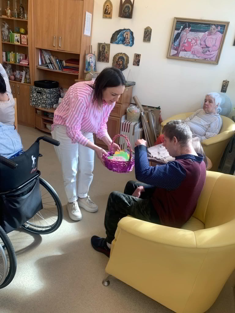 Przedszkolanka przekazuje kartkę świąteczną podopiecznemu
