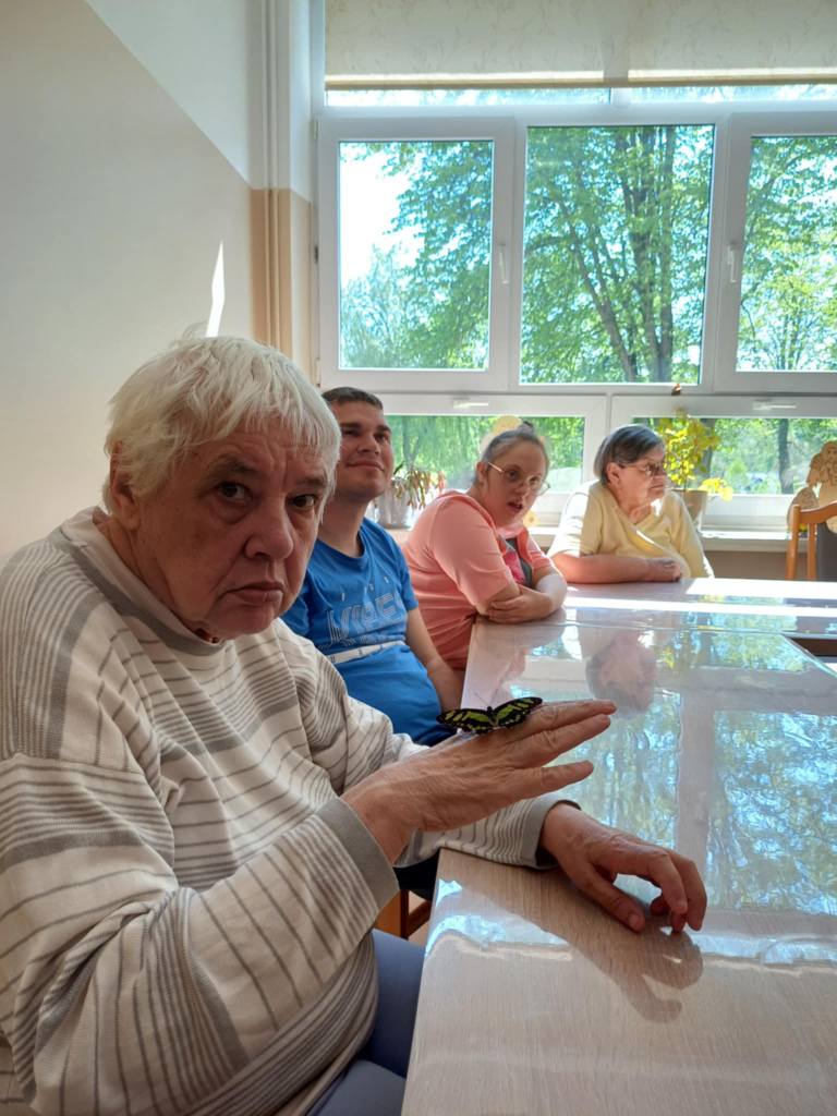 Podopieczna trzyma motyla na dłoni