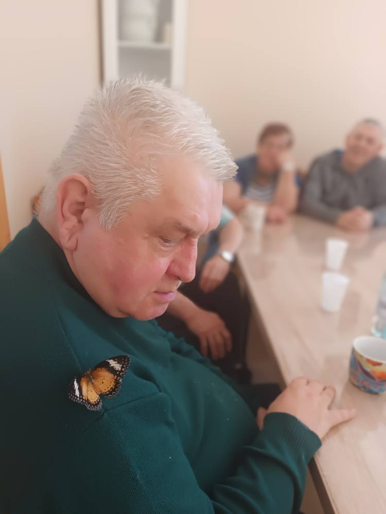 Podopieczny trzyma motyla na ramieniu