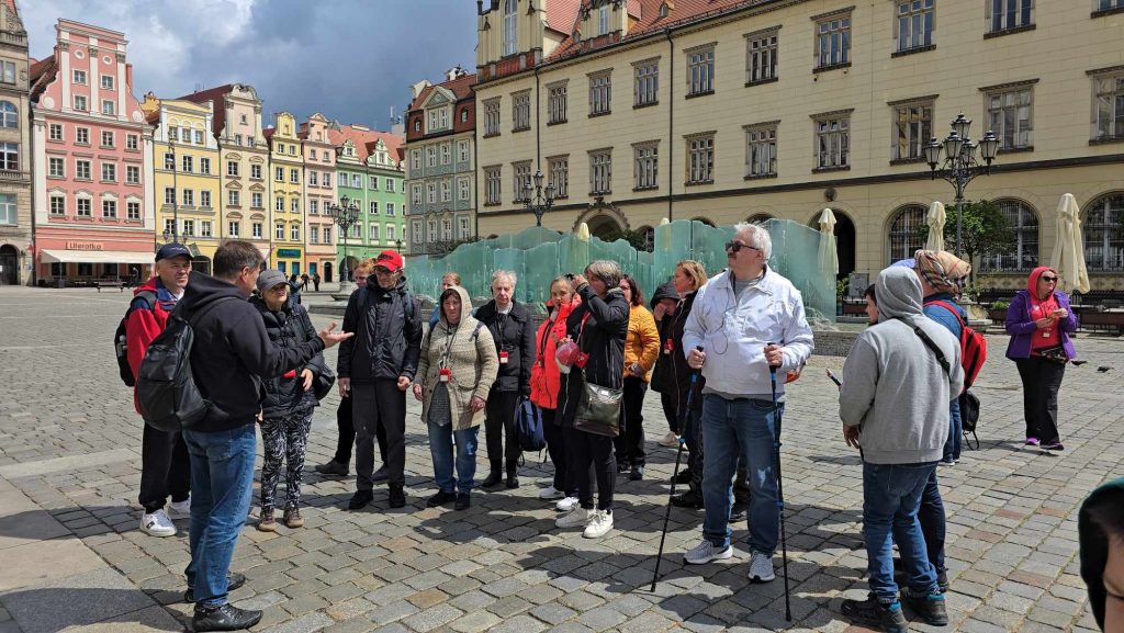 Grupa osób stoi na rynku we Wrocławiu