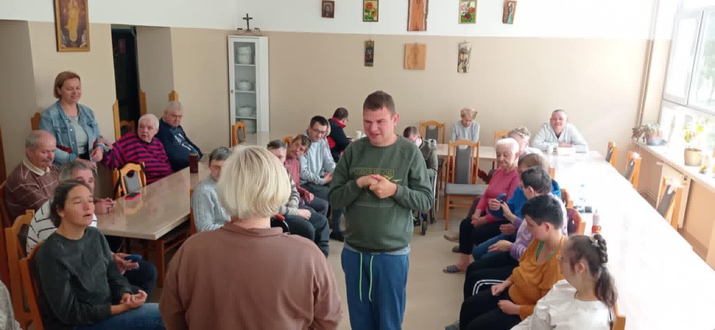 Podopieczni wykonują proste ćwiczenia fizyczne pod przewodnictwem terapeutów