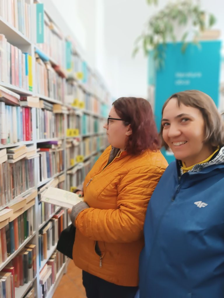 Podopieczne wybierają książki w bibliotece