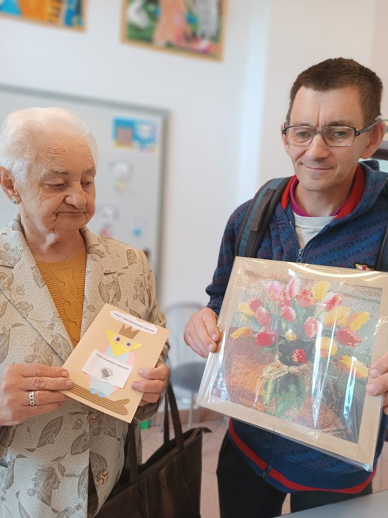 Podopieczni demonstrują przygotowane prezenty dla pracowników biblioteki