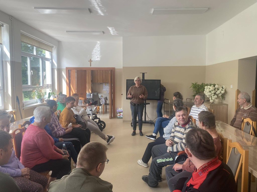 Podopieczni wykonują proste ćwiczenia fizyczne pod przewodnictwem terapeutów