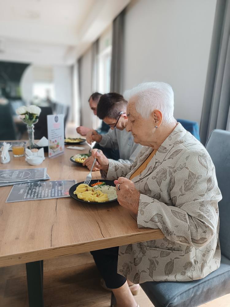 Podopieczni jedzą obiad w restauracji