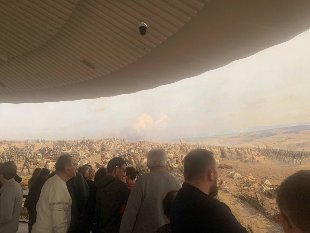 Grupa osób zwiedza Panoramę Racławicką
