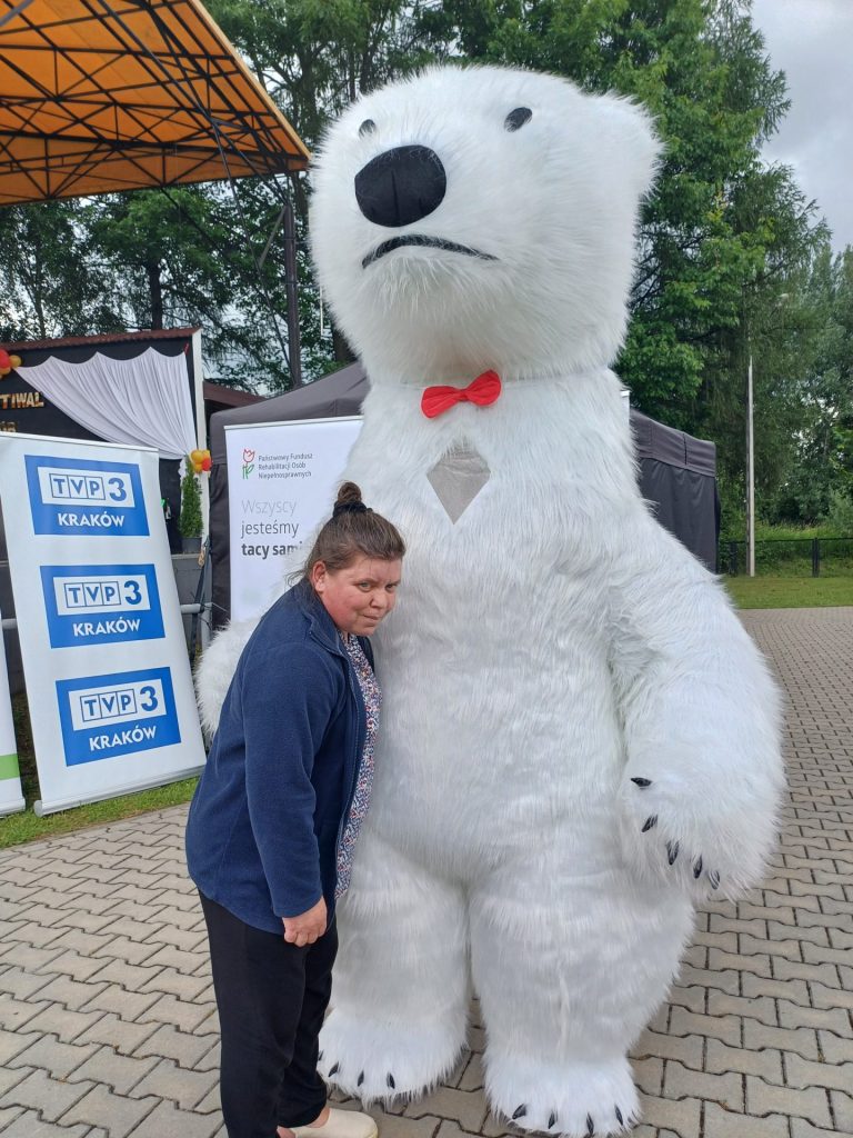 Podopieczna pozuje z wielkim misiem