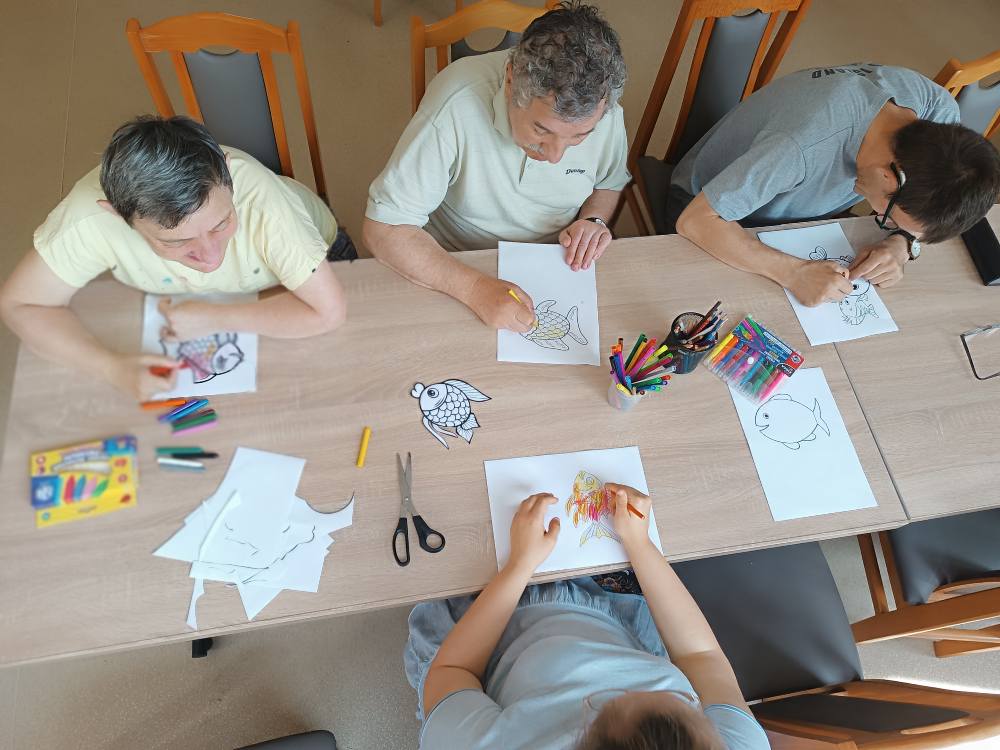 Podopieczni kolorują obrazki kredkami