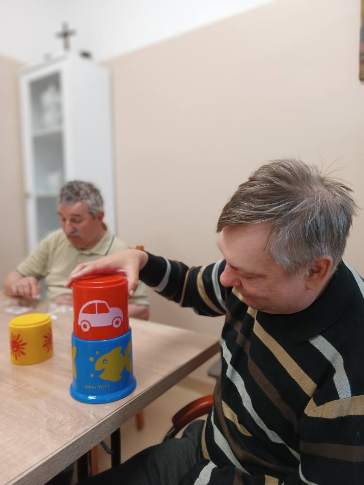 Podopieczny układa kolorową piramidę
