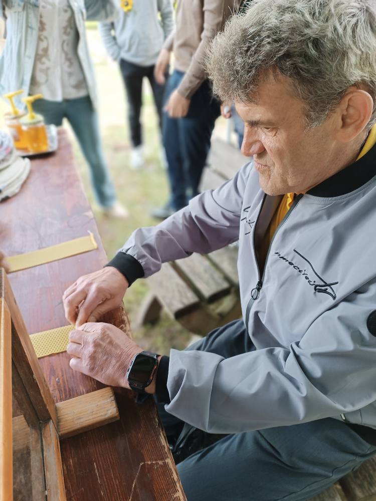 Podopieczni robi świecę z wosku pszczelego