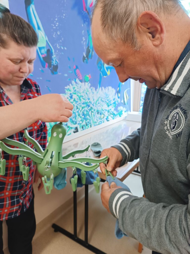 Podopieczni wieszają skarpetki na suszarce