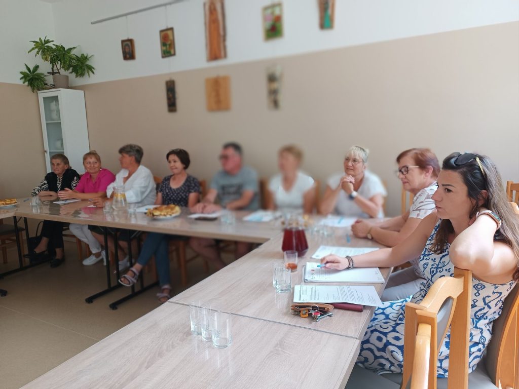 Grupa osób słucha prelekcji
