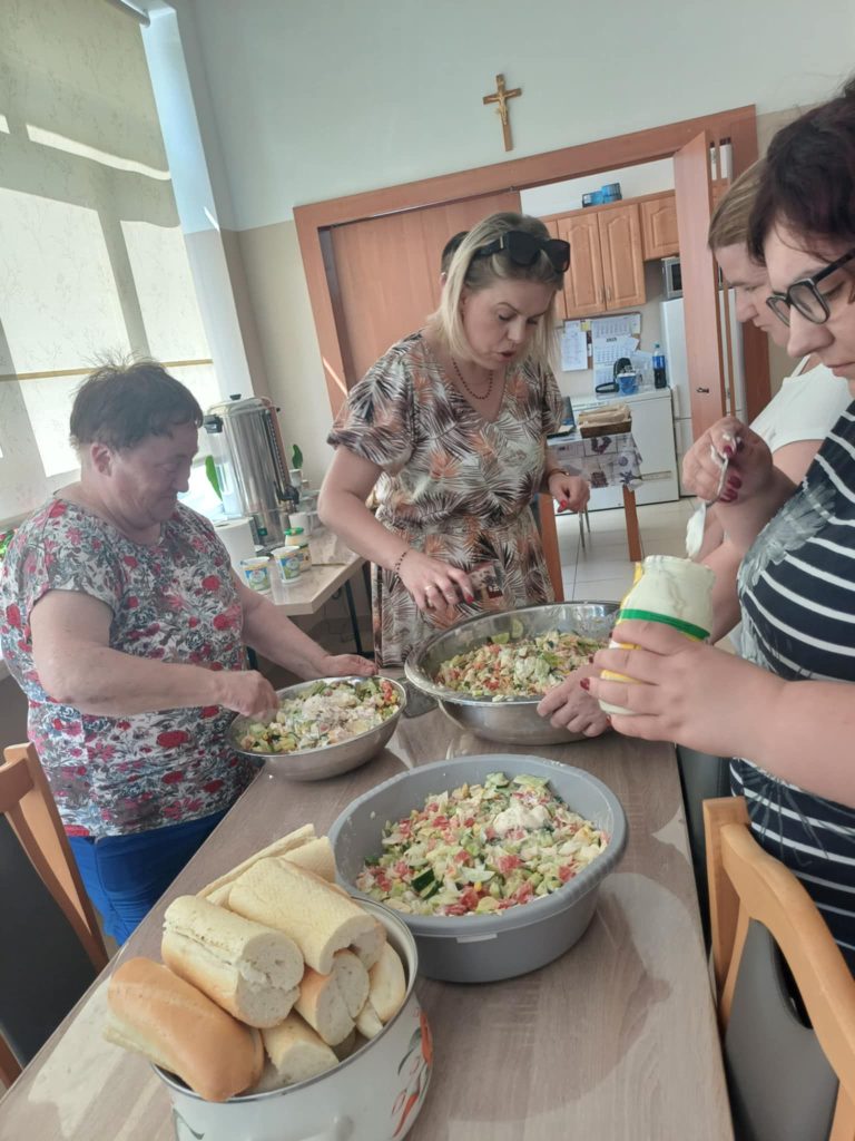 Grupa osób przygotowuje sałatkę jarzynową
