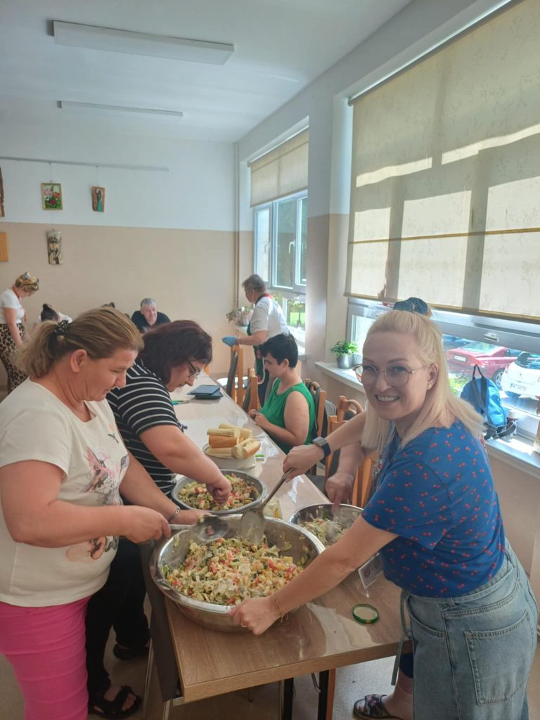 Grupa osób przygotowuje sałatkę jarzynową