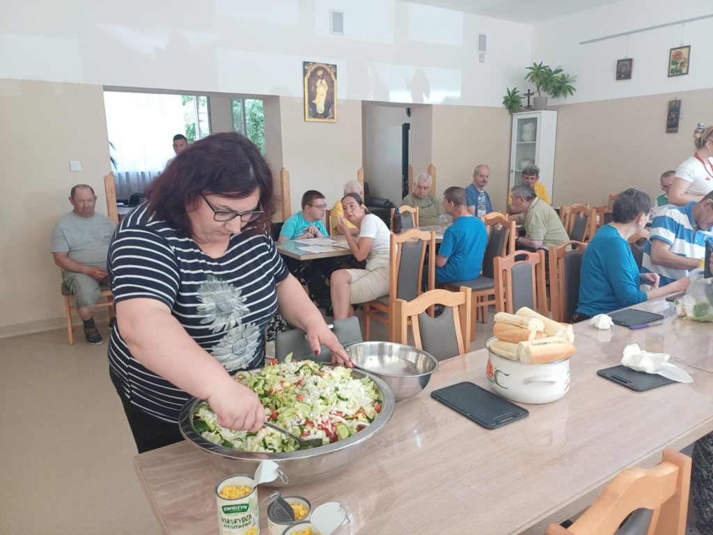 Grupa osób przygotowuje sałatkę jarzynową