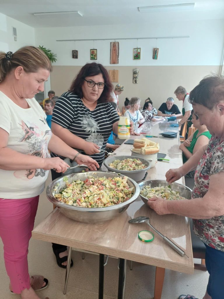 Grupa osób przygotowuje sałatkę jarzynową