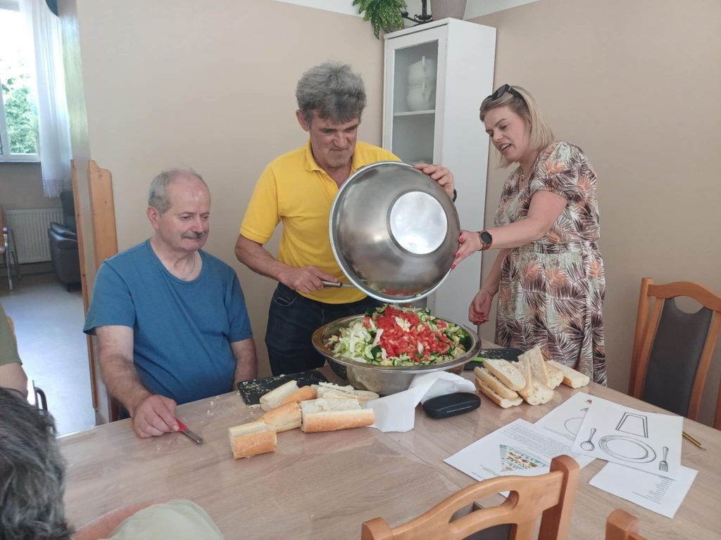 Grupa osób przygotowuje sałatkę jarzynową