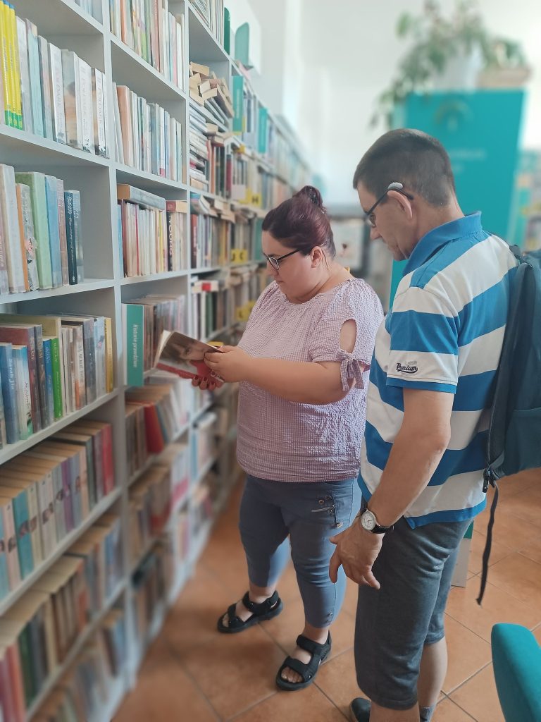 Podopieczni wybierają książki w bibliotece