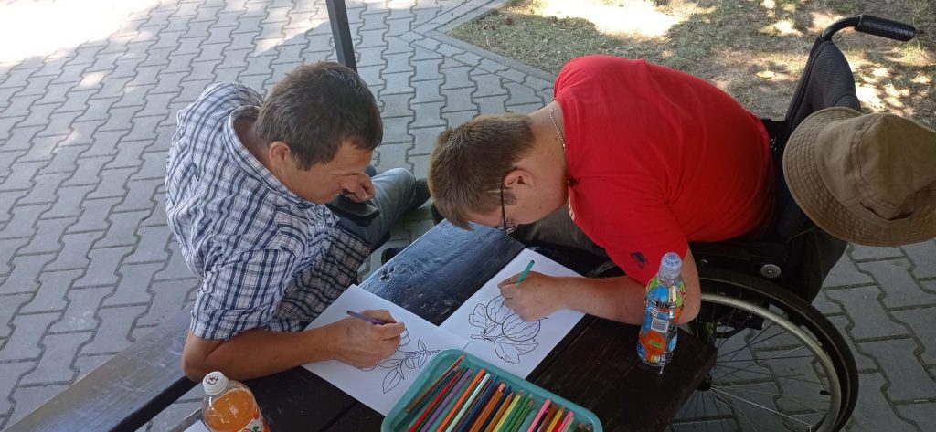 Podopieczni kolorują obrazki z owocami