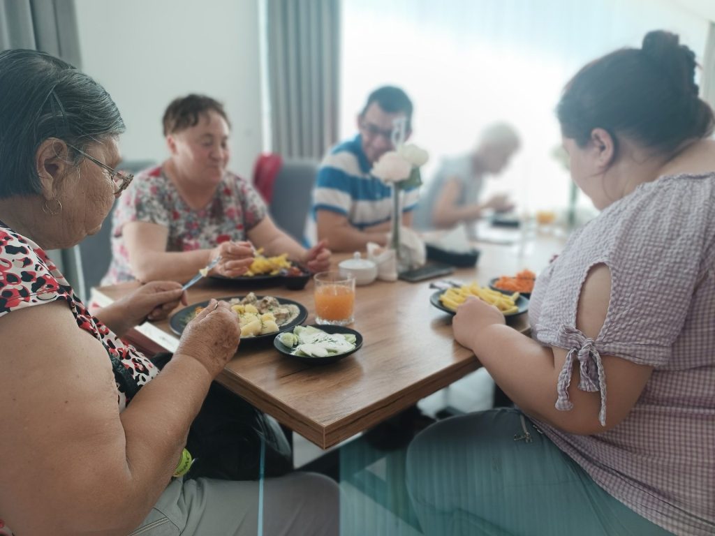 Podopieczni jedzą posiłek w restauracji