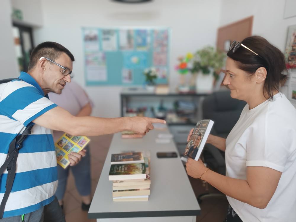 Podopieczni wypożyczają książki w bibliotece