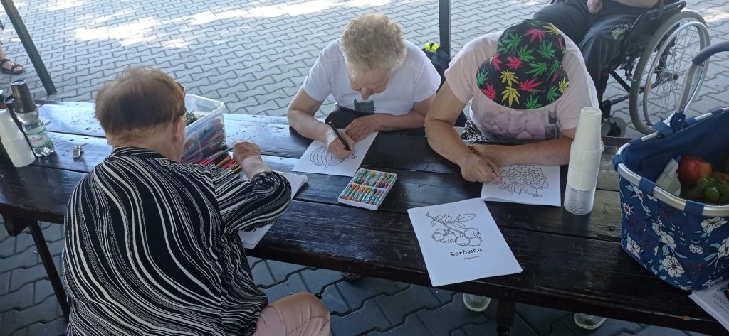 Podopieczni kolorują obrazki z owocami