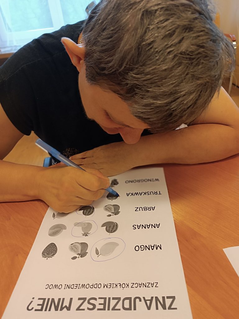Podopieczna rozwiązuje zadania o tematyce owocowej
