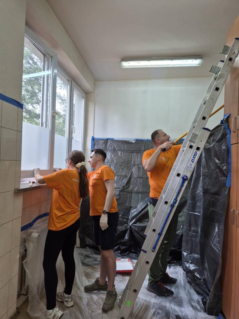 Wolontariusze z ING malują pomieszczenie w ŚDS