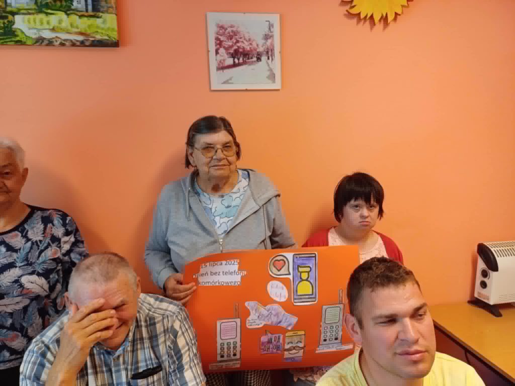 grupa podopiecznych prezentuje wykonany przez siebie plakat informacyjny